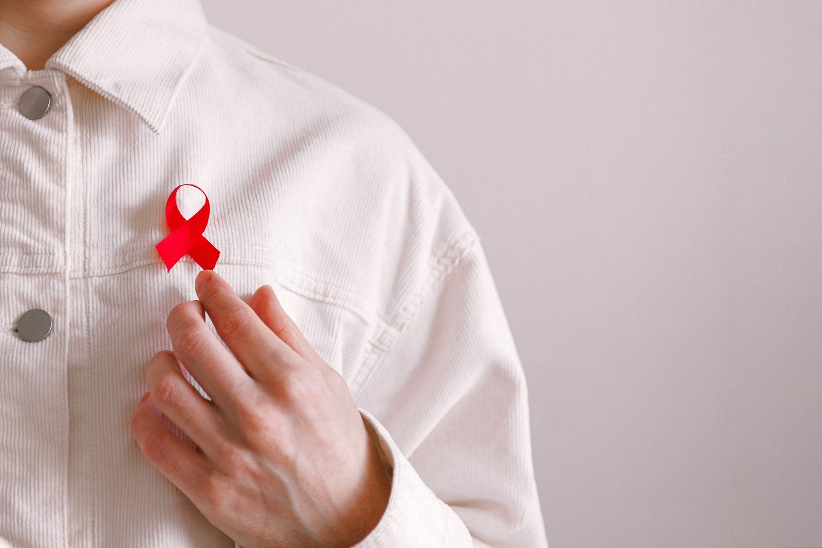 Мужчина с красной ленточкой на рубашке во Всемирный день борьбы со СПИДом